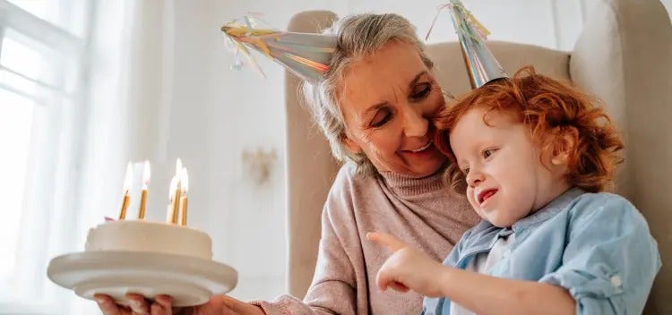 Image of a grandmother looking at a child blowing out candles on a cake (not actual patients) mobile