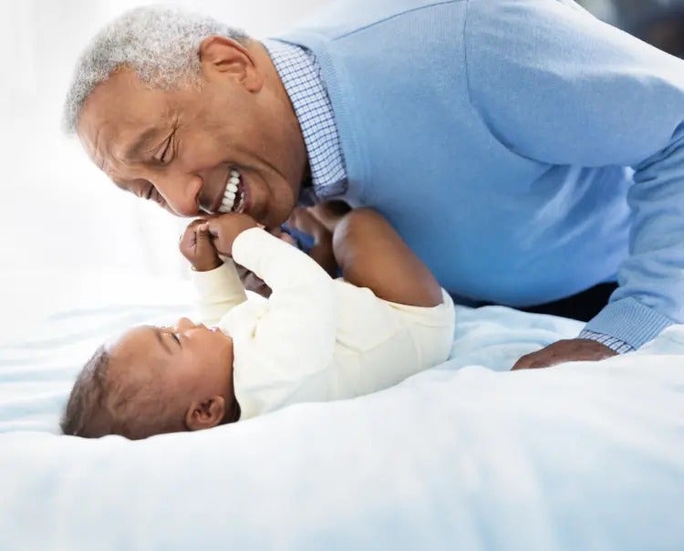 Image of grandfather playing with a baby (not actual patients) mobile