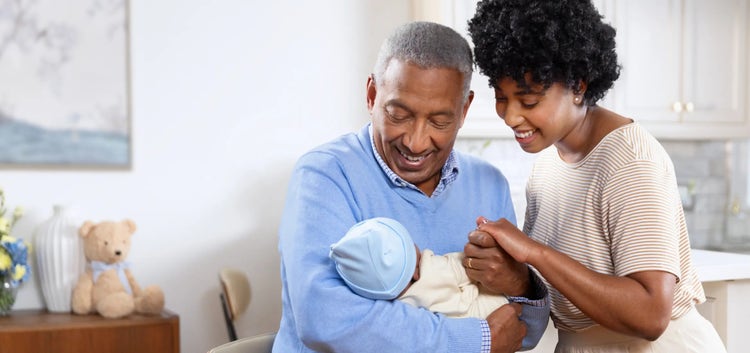 Image of a grandfather and mother looking at a baby (not actual patients)