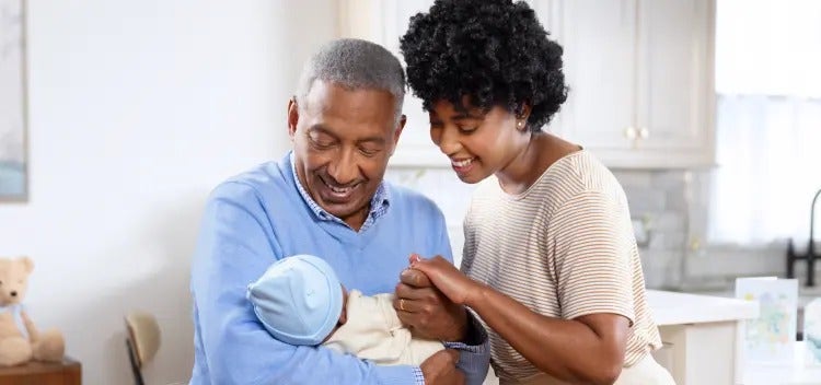 Image of a grandfather and mother looking at a baby (not actual patients) mobile