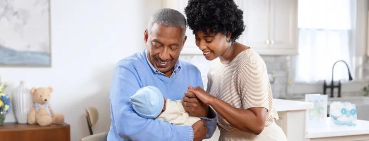 Image of a grandfather and mother looking at a baby (not actual patients)