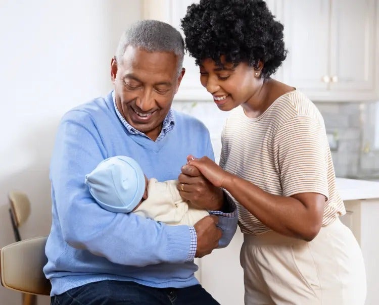 Image of a grandfather and mother looking at a baby (not actual patients) mobile