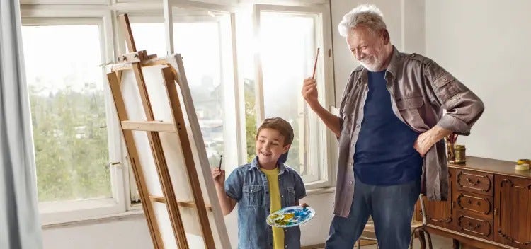 Image of an older man and a boy painting on an easel (not actual patients) mobile