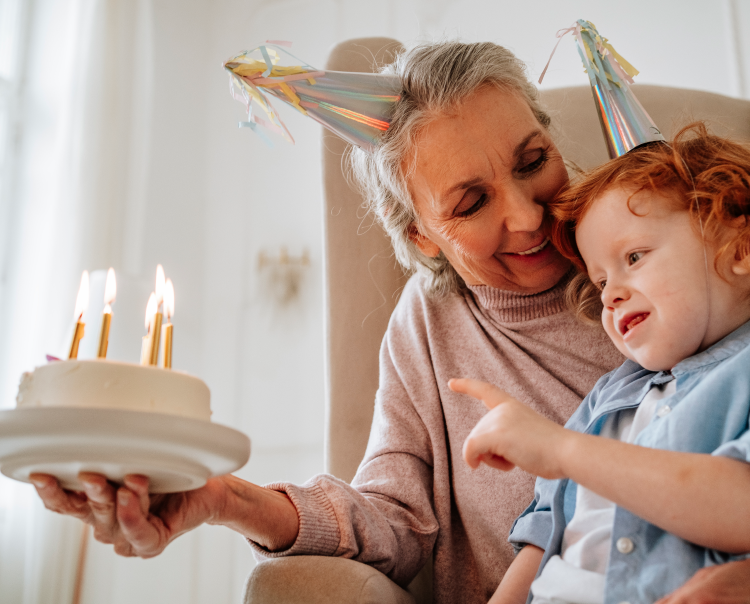 Image of a grandmother looking at a child blowing out candles on a cake (not actual patients) mobile